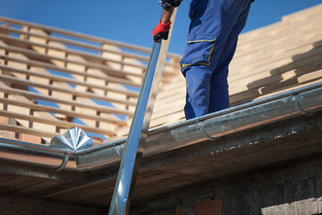 Poster - Low angle shot of a construction worker on a roof of a building