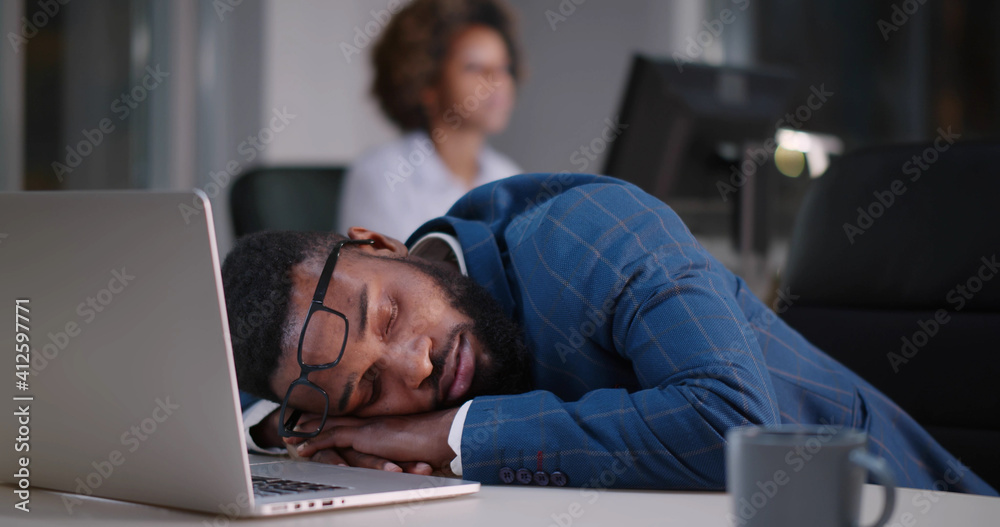 Young african businessman with eyeglasses worked late and fell asleep on desktop - obrazy, fototapety, plakaty 