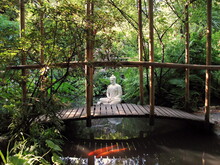 A Statue Of Buddha Sitting In A Pond. Tranquility Background. Couple Of Red Fishes Is Swimming In The Pond.
