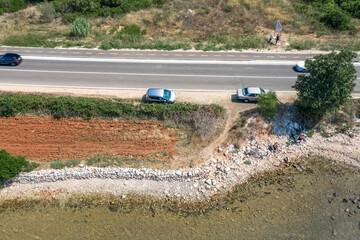 Wall Mural - Aerial drone shot of car off road stuck at Adriatic coastline near Galesnjak in Dalmatia Croatia