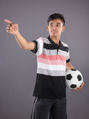 Wall Mural - Smiling Indian teen boy holding soccer ball or football	
