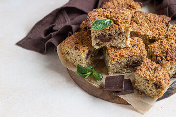 Wall Mural - Oatmeal squares with chocolate decorated, light concrete background. Diet bars. Healthy bakery for breakfast or dessert.