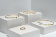 Golden bracelets and ring on white cubes eith copy space