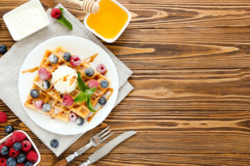 Canvas Print - Tasty waffles with fresh berries and ice cream on brown wooden background