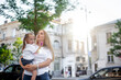 © Вероника Зеленина - Mother and daughter walking outdoor in the street of the city, people spending time with family together against the sun