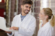 © auremar - male and female workers in brewery looking at laptop