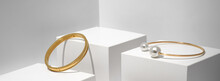 Panoramic Shot Of Two Golden Bracelets On White Geometric Background