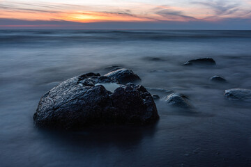 Wall Mural - stones at sea at sunset and in the long exposition