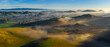 Aerial view countryside farm hills and valleys at sunrise with fog, California