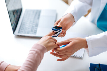 close up photo of oxygen pressure measurement. female hands of a doctor and patient. doctor uses a p