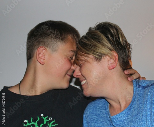 Mother And 13 Year Old Son Bonding With Foreheads Touching.  Respect And Love