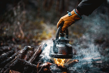 Wall Mural - with knife, water bottle and titanium mug near the fire outdoors. bushcraft, adventure, travel, tourism and camping concept.