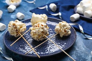 Plate with tasty popcorn balls on color background