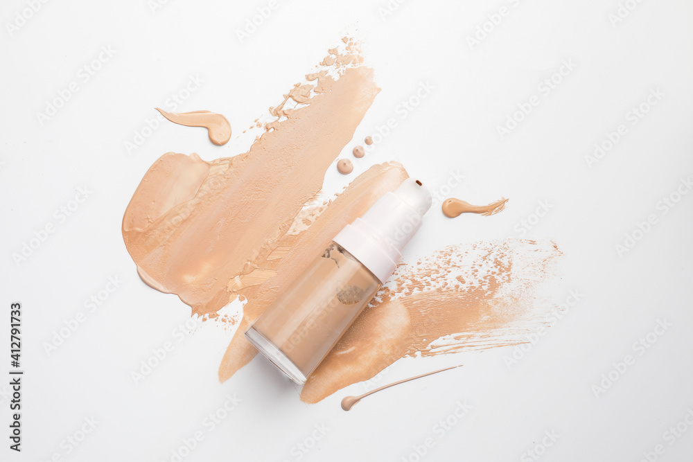 Bottle of makeup foundation and sample on white background