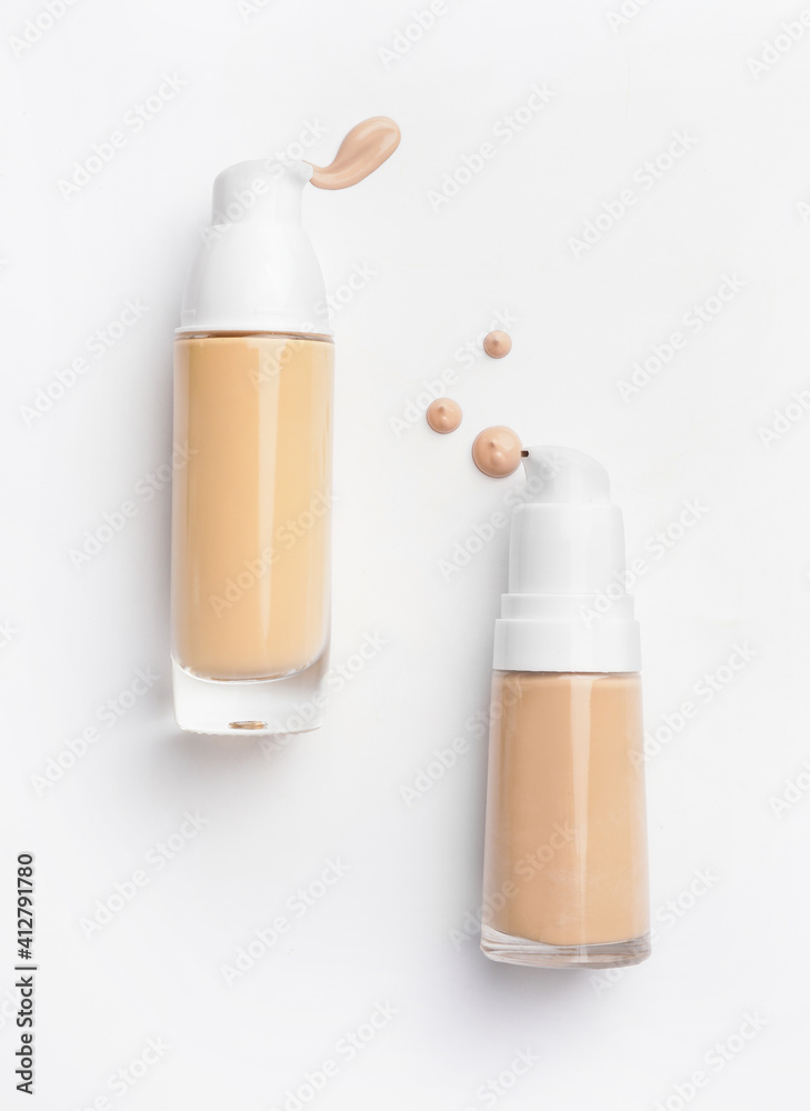 Bottles of makeup foundation and samples on white background