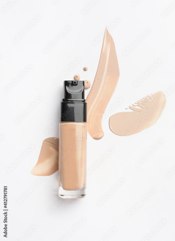 Bottle of makeup foundation and samples on white background