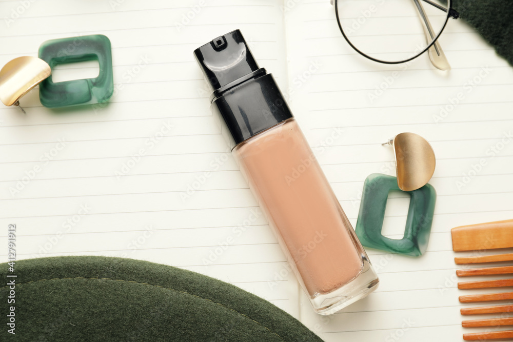 Bottle of makeup foundation and accessories, closeup