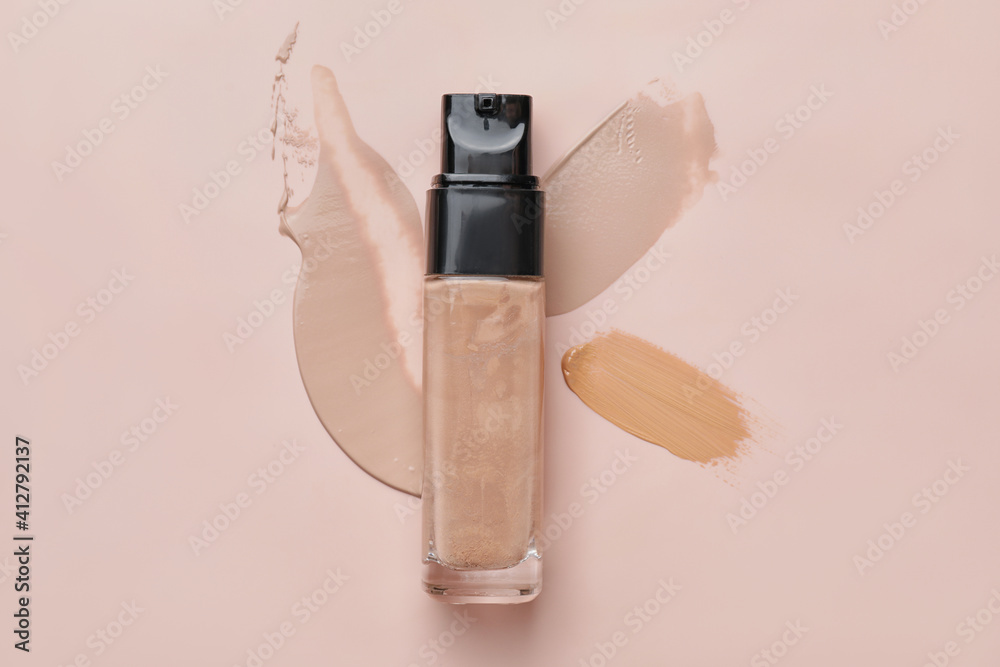 Bottle of makeup foundation and samples on color background