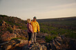 © StratfordProductions - Handsome man looking at beautiful girl smiling after hiking and reaching mountain cliff edge