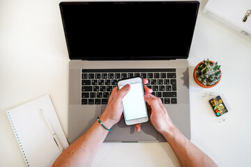 Canvas Print - the man works with modern technologies, a laptop and a mobile phone. top view of a programmer or bus