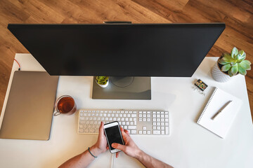 Canvas Print - the man works with modern technologies, a laptop and a mobile phone. top view of a programmer or bus