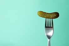 Fork With Pickled Cucumber On Mint Background