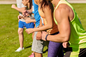 Sticker - fitness, sport, race and healthy lifestyle concept - group of friends or sportsmen with badge numbers on start of running marathon outdoors