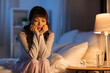© Syda Productions - people, bedtime and rest concept - sad asian woman sitting on bed at night
