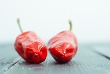 Wall Mural - chili on black wood table, side view