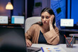 © DC Studio - Lady in corporate office looking tired working on laptop doing overtime. Smart woman sitting at her workplace in the course of late night hours doing her job.