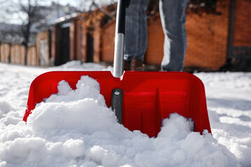 Wall Mural - Person shoveling snow outdoors on winter day, closeup