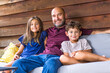 © digitalskillet1 - Hispanic father sitting and hugging his children.