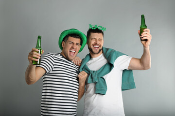 Wall Mural - Emotional men in St Patrick's Day outfits with beer on light grey background