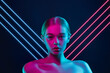 Future. Portrait of female fashion model in neon light with neoned blue glowing lines on dark studio background. Beautiful woman with trendy make-up and well-kept skin. Vivid style, beauty concept.