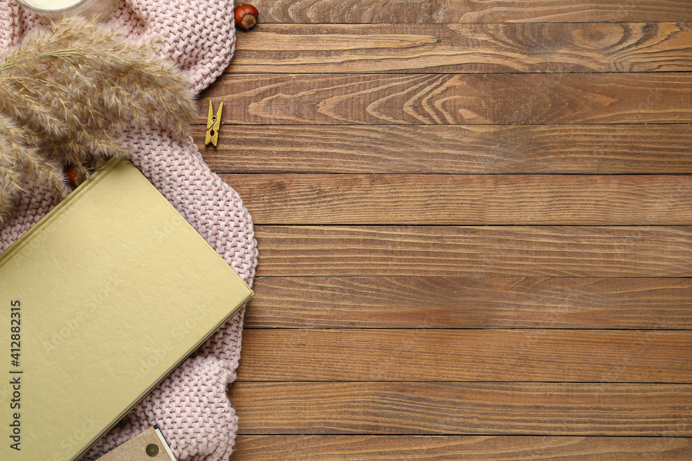 Blank book, hazelnuts and reed on wooden background