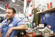 © Mint Images - Portrait of a smiling Caucasian male mechanic in an auto repair shop