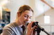 © Mint Images - Fourteen year old teenage girl playing her guitar and singing at home in loft space