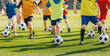 Football soccer children training class. Kids practicing football on grass field. Group of school children running and kicking soccer balls on summer training camp
