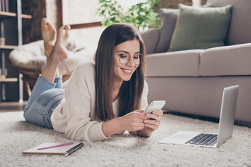 Sticker - Full length photo of cheerful attractive young lady lie floor look phone write message wear glasses good mood inside home indoors