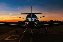 A Single-engine Plane Is Parked On The Runway, Bathed In The Evening Sun. Beautiful Color View Of The Plane.