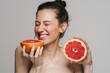 © Drobot Dean - Happy half-naked woman smiling while posing with grapefruit