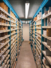 many shelves filled with spare parts stand in the parts store of a car repair shop