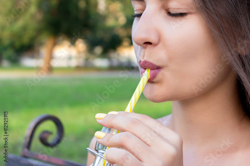 Smiling Woman Drinking Juice While Sitting In Public Park © mykola sosiukin/EyeEm