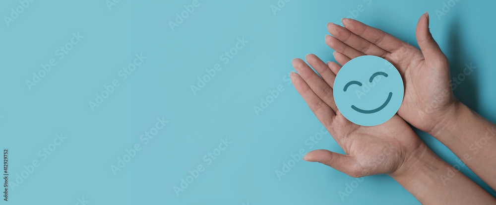 Hand holding blue paper cut happy smile face, positive thinking, mental health assessment , world mental health day concept - obrazy, fototapety, plakaty 