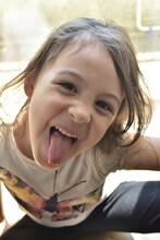 Portrait Of Smiling Cute Girl Sticking Out Tongue