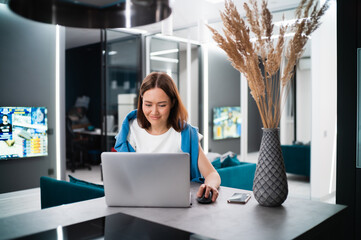 Female gamer playing video game from home using laptop. Professional player testing online video games on her personal computer with modern technology network wireless.