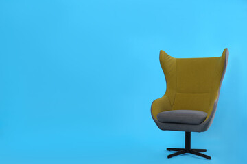 Comfortable office chair on light blue background, space for text