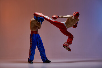 Sparring of fighting males boxers. Jumping male fighter kicking knockout competitor, martial arts, mixed fight concept 