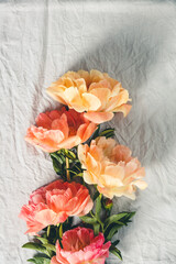 Wall Mural - flat-lay of beautiful peony flowers over grey linen table cloth background, top view, copy space