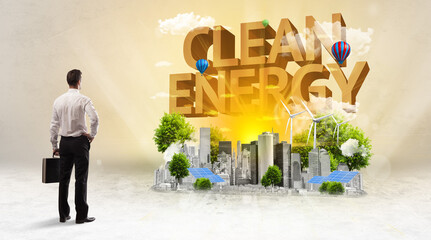 Rear view of a businessman standing in front of CLEAN ENERGY inscription, Environmental protection concept